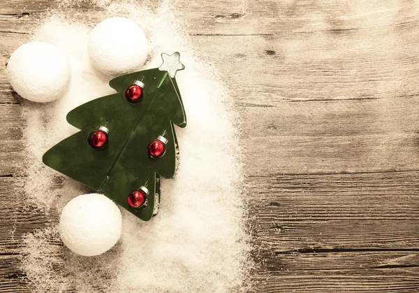 Cartolina con albero di Natale, palle di Natale palle di neve e neve su sfondo di legno — Foto Stock