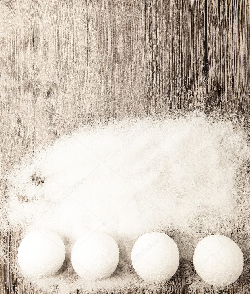 Christmas card with snowballs and snow on a wooden background.