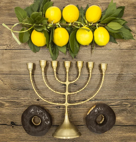 Bougeoir juif avec une branche de citrons beignets et corne de chèvre. Symboles de la grande fête de Hanoukka. Sur fond en bois — Photo