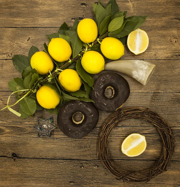 Rama limones donas y cuerno de cabra. Símbolos de la gran fiesta de Janucá. Sobre fondo de madera . — Foto de Stock