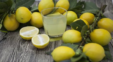 Taze sulu limon ve bir bardak ahşap arka plan üzerinde ev yapımı limonata