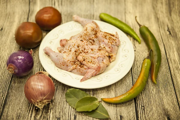 Surowego świeżego kurczaka na Porcelanowy talerz z cytryny i chili cebuli na drewniane tła — Zdjęcie stockowe
