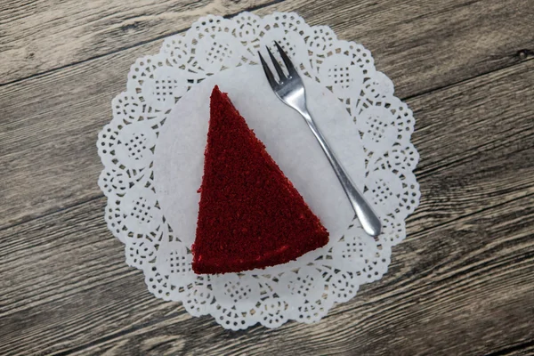 Savoureux morceau de gâteau de velours rouge, sur une serviette blanche et une fourchette à dessert sur un fond en bois — Photo