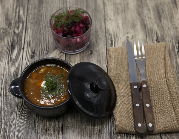 Beet salad and tomato, red pepper soup, sauce with olive oil, rosemary and smoked paprika with fork and knife on a wooden background — Stock Image Beet salad and tomato, red pepper soup, sauce with olive oil, rosemary and smoked paprika with fork and knife on a wooden background Stock Photo