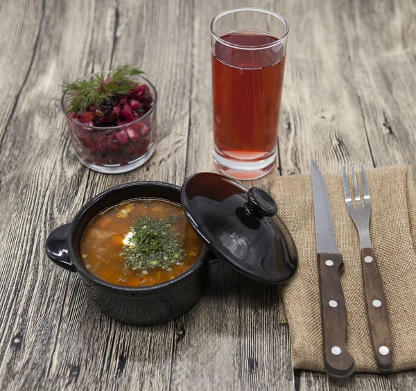 Beet salad and tomato, red pepper soup, sauce with olive oil, rosemary and smoked paprika with fork and a glass of juice and knife on a wooden background — Stock Image Beet salad and tomato, red pepper soup, sauce with olive oil, rosemary and smoked paprika with fork and a glass of juice and knife on a wooden background Royalty Free Stock Photos