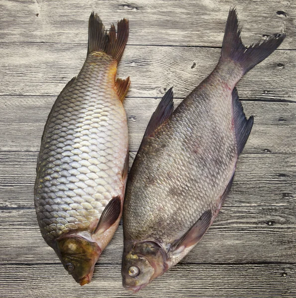 Due grandi carpe fresche di pesce vivo sdraiato su una tavola di legno — Foto Stock