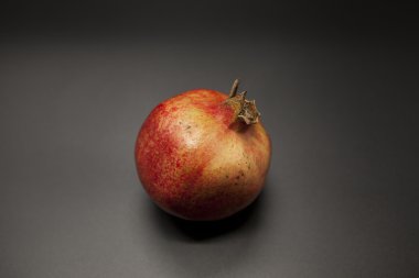 İspanyol sulu olgun nar closeup karanlık bir arka plan üzerinde