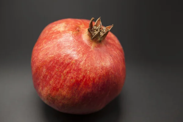 Spanish juicy ripe pomegranate closeup on a dark background — Stock Photo, Image