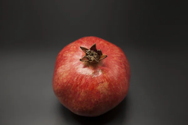 Zwei fruchtsaftige spanische Granatäpfel auf dunklem Hintergrund. — Stockfoto