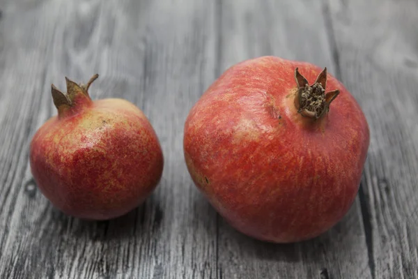 Two fruit juicy Spanish pomegranate on the wooden background — Stock Photo, Image