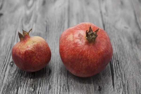 Two fruit juicy Spanish pomegranate on the wooden background — Stock Photo, Image