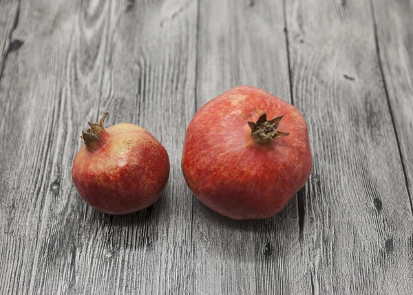 Two fruit juicy Spanish pomegranate on the wooden background — Stock Photo, Image