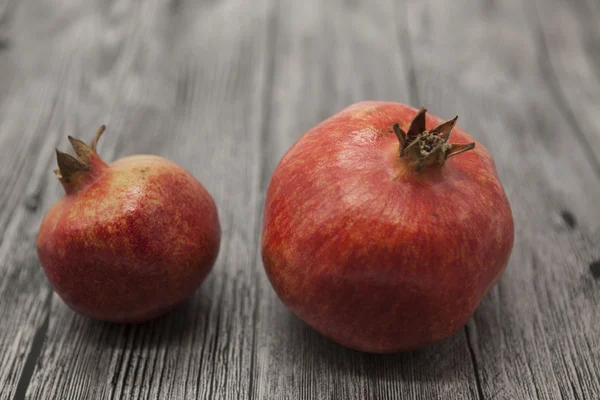 Two fruit juicy Spanish pomegranate on the wooden background — Stock Photo, Image