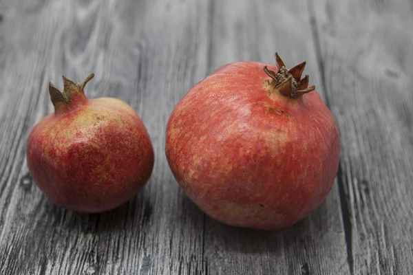 Two fruit juicy Spanish pomegranate on the wooden background — Stock Photo, Image