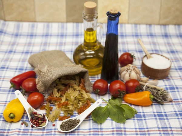 Fusilli итальянская паста набор для создания: помидоры черри, оливковое масло, бальзамический соус, чеснок, специи, морская соль, салат на деревенском столе — стоковое фото