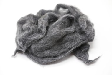 Gray piece of Australian sheep wool Merino breed close-up on a white background