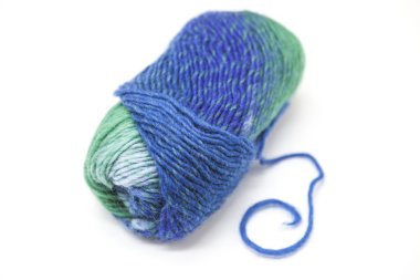 Green blue ball of wool yarn for knitting close up on a white background.