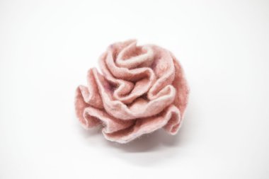 Beautiful pink rose flower milled wool on a white background.