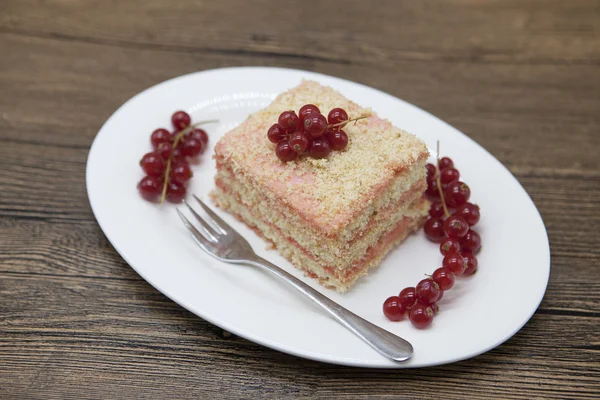 Свежий вкусный диетический торт с ягодной красной смородиной на диете Дукан на фарфоровой тарелке с ложкой на деревянном фоне . — стоковое фото