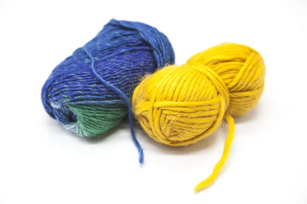 Bola verde azul e amarela de fios de lã para tricotar de perto em um fundo branco — Fotografia de Stock