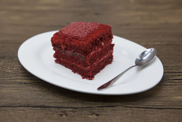 Red Velvet, fresh delicious diet cake  at Dukan Diet on a porcelain plate with a spoon  on a wooden background. — Stock Fotó