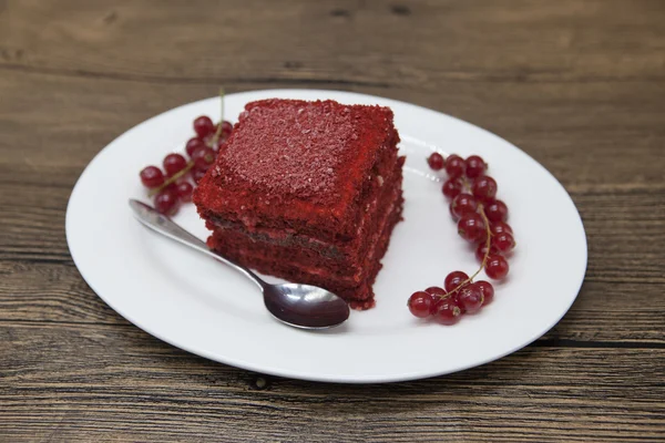 Red Velvet, fresh delicious diet cake with red currant at Dukan Diet on a porcelain plate with a spoon on a wooden background — Stock Fotó