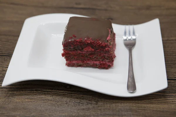 Red Velvet, fresh delicious diet cake with red currant at Dukan Diet on a porcelain plate with a spoon on a wooden background — Zdjęcie stockowe