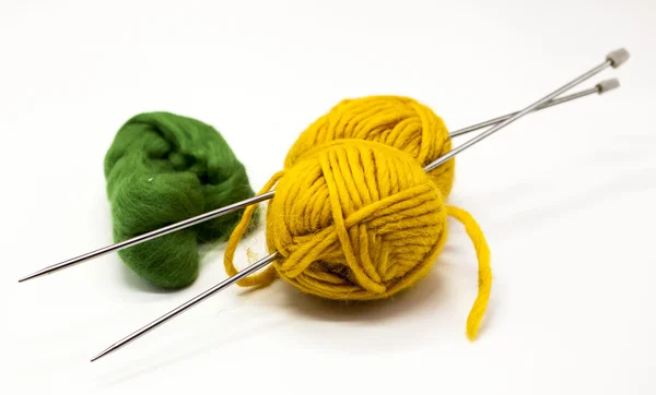 Green and yellow balls of yarn for knitting with spokes on a white background. — Stock Photo, Image