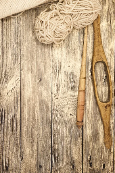 Eccellente mocap due vecchi mandrini in legno con una palla di filo di lana per la fabbricazione di fili di lana su uno sfondo di legno — Foto Stock