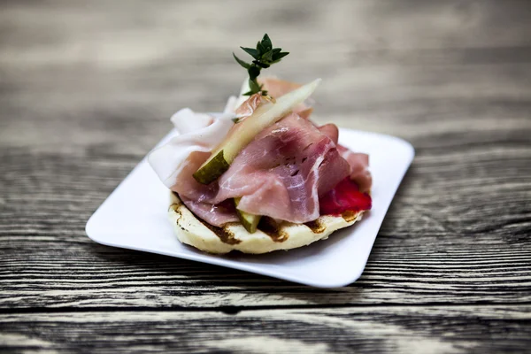 Frescas deliciosas tapas espanholas com hamon no fundo de madeira. Excelente fundo para restaurante, café — Fotografia de Stock