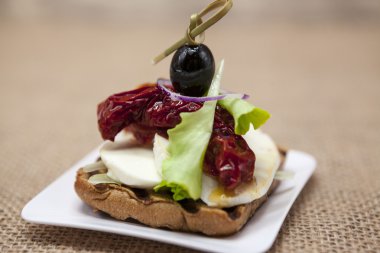 Bir rustik mozzarella ve kurutulmuş domates zeytin ile lezzetli İspanyolca tapas.