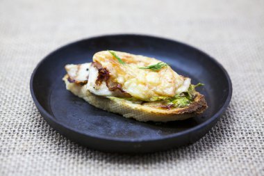 Ev pişmiş tavuk peynir, soğan, Şili biber, sarımsak Tekstil arka plan bir dökme demir tava üzerinde sıcak sandviç.