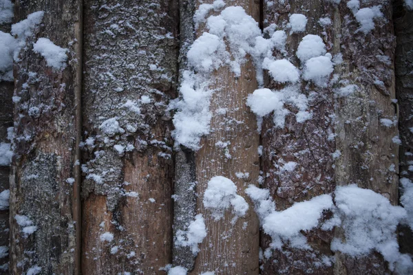 A wooden fence in the winter with snow, close-up