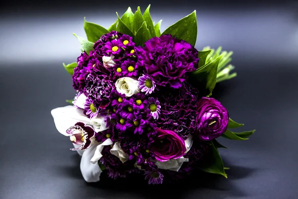 Beautiful bouquet of bride purple flowers on a dark background. — Stock Photo, Image