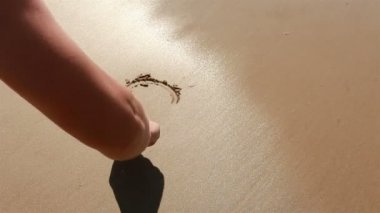 el kum bir kalp çizer. su ile durulama.