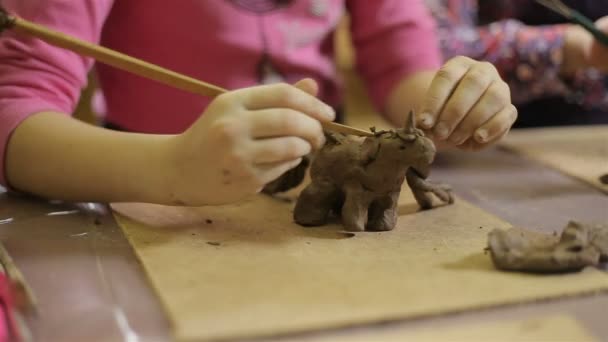 Children molded out of clay figurines. — Stock Video