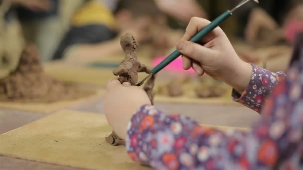 Children molded out of clay figurines. — Stock Video