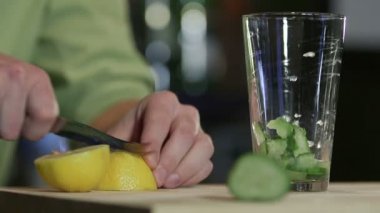 Barmen kokteylleri hazırlar. Limon suyu. Salatalık tini.