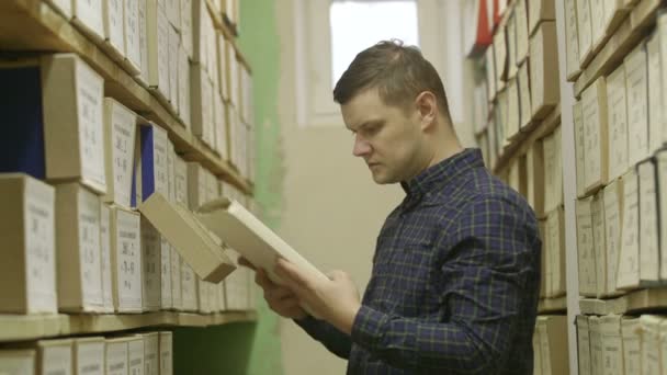 Людина дивиться документи в архіві. 3 постріли — стокове відео