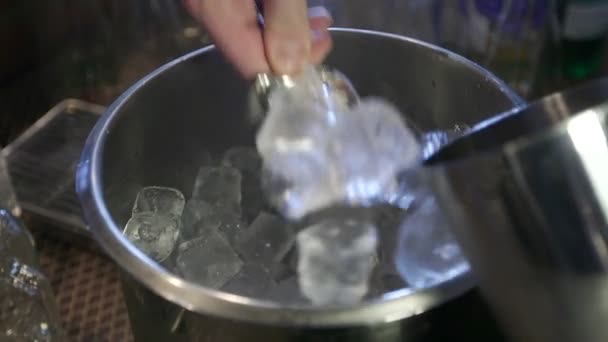 Cantinero pone hielo en una coctelera . — Vídeo de stock