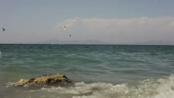Kitesurfers ride on the beach. — Stock Video