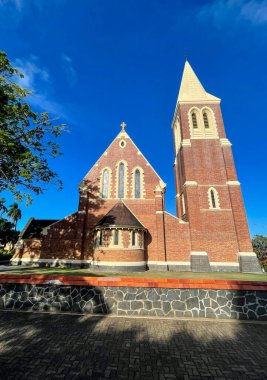 1926 'da İngiliz Gotik tarzında önemli bir çan kulesiyle inşa edilen ve Bundaberg, Queensland, Avustralya' daki Woongarra Caddesi 'nde bulunan tarihi İsa Kilisesi Kilisesi' nin cephe manzarası.