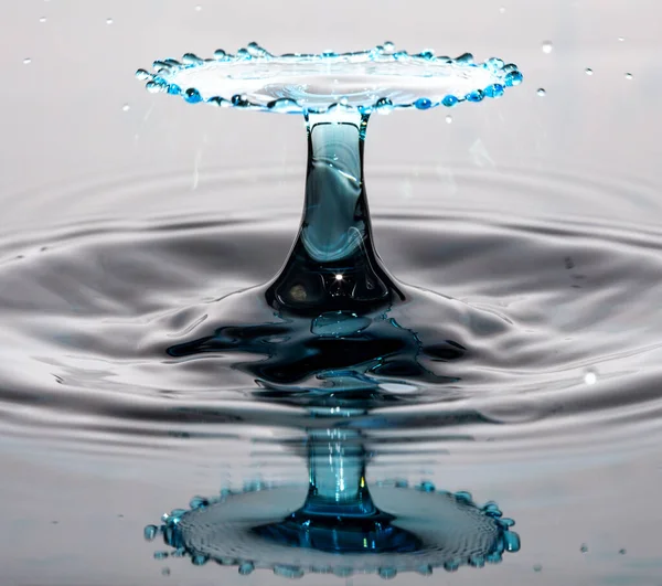 Kollision Mit Blauem Wassertropfen Und Reflexion Auf Einer Nahtlosen Oberfläche — Stockfoto