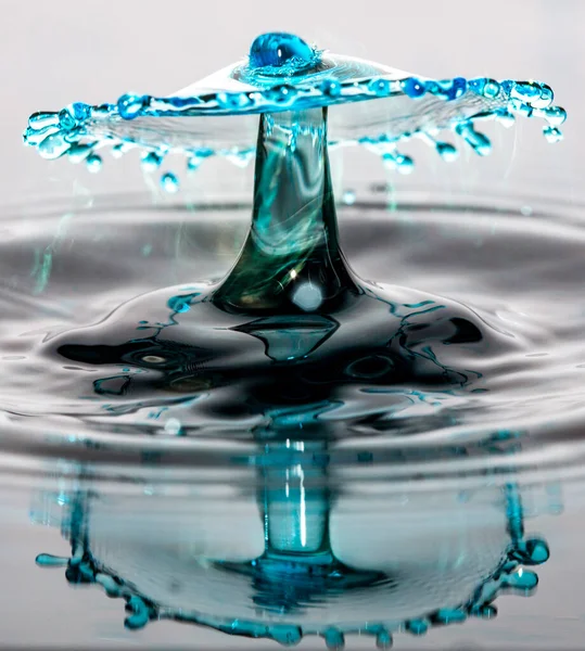Kollision Mit Blauem Wassertropfen Und Reflexion Auf Einer Nahtlosen Oberfläche — Stockfoto