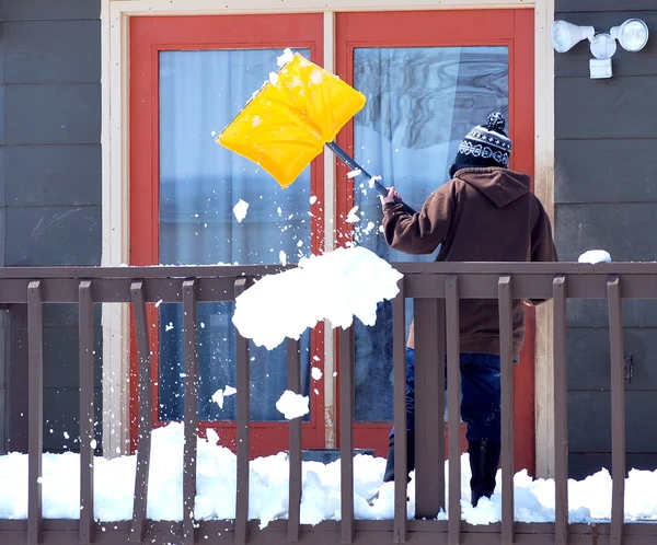 Зрелая женщина убирает снег . — стоковое фото