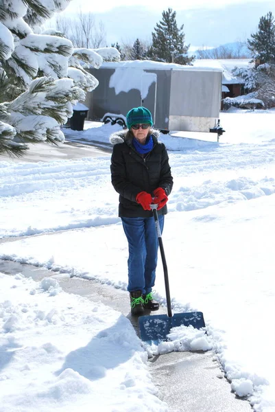 Gammal Kvinnlig Senior Skottning Snö Uppfarten Utomhus — Stockfoto