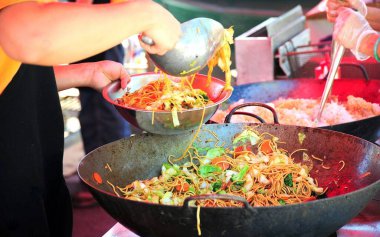 Çin usulü kızarmış tavuk, dışarıda tavada pişirilmiş lo mein..