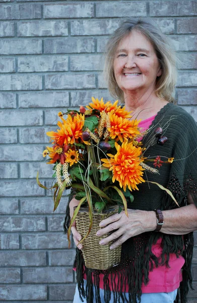 Açık Havada Çiçekleri Tutan Olgun Sarışın Kadın — Stok fotoğraf