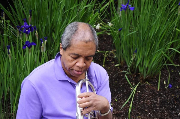 Afrikansk Amerikansk Manlig Jazzmusiker Blåser Sitt Flugelhorn Blomsterträdgård Utanför — Stockfoto