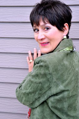 Olgun yaşlı kadın ifadeleri dışarıda duvara karşı..